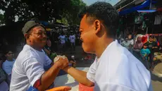 Pedagang pasar saat mengikuti lomba panco antar pedagang dan pengunjung pasar di Pasar Rakyat Ciseeng, Bogor, Sabtu (20/7/2024). (merdeka.com/Arie Basuki)