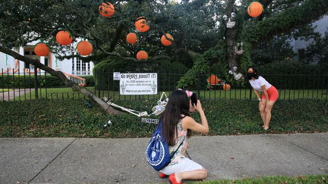 Seorang wanita berpose dengan latar dekorasi Halloween di New Orleans, Louisiana, Amerika Serikat, pada 10 Oktober 2020. Tiga pekan sebelum perayaan Halloween, warga New Orleans mulai mendekorasi rumah mereka untuk menyambut festival tersebut. (Xinhua/Lan Wei)