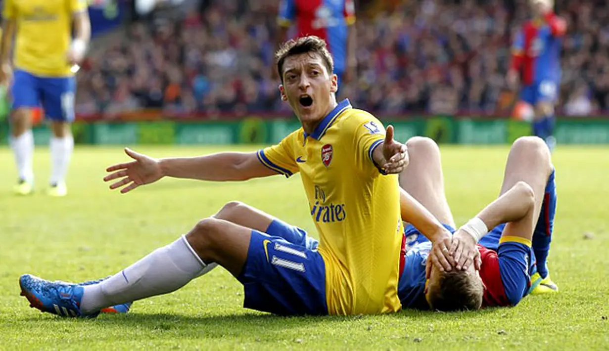 Reaksi Mesut Ozil saat terjatuh di lapangan pada pertandingan Liga Premier Inggris antara Crystal Palace vs Arsenal di Selhurst Park, London (26/10/2013). (AFP/Ian Kington).