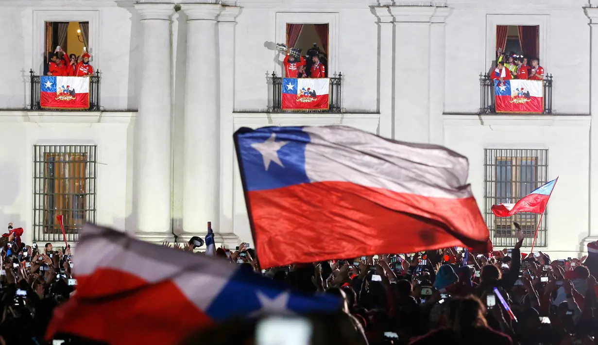 Pemain Chile memperlihatkan trofi dari balkon Istana ke suporter Chile usai mengalahkan Argentina di final Copa America 2015 di Istana nasional (4/7/2015). Chili menang lewat adu penalti atas Argentina dengan skor 4-1. (REUTERS/Carlos Garcia Rawlins)