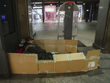 Seorang tunawisma mempersiapkan diri untuk malam hari di pusat kota Milan, Italia utara, 27 November 2020. Tidak ada tempat di Italia yang kemiskinan lebih jelas daripada di Lombardy, wilayah utara yang sempat menjadi episentrum penularan COVID-19. (AP Photo/Luca Bruno)