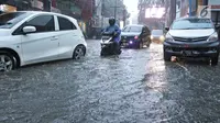 Sejumlah kendaraan menerobos genangan air di kawasan Kemang, Jakarta Selatan, Kamis (18/10). Akibat hujan deras, kawasan di Jalan Kemang kembali tergenang air. (Liputan6.com/Herman Zakharia)