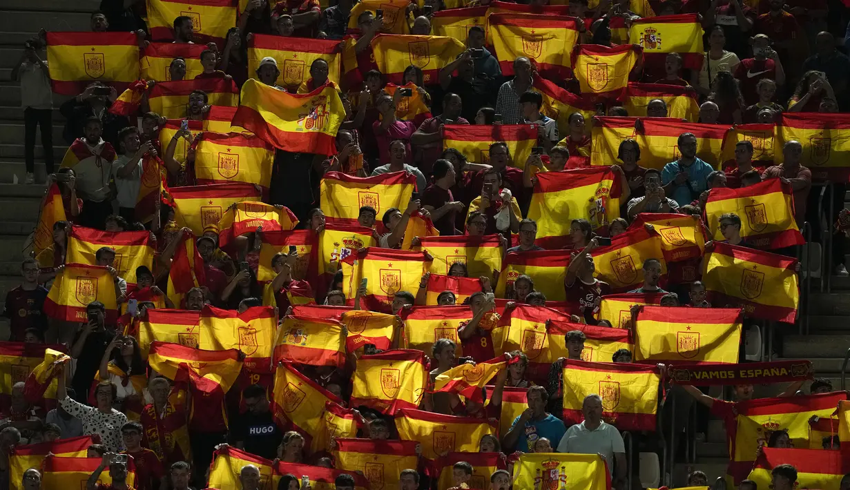 Para suporter Spanyol membentangkan sejumlah bendera negara mereka saat laga lanjutan UEFA Nations League melawan Denmark di Nueva Condomina Stadium, Murcia, Spanyol, Minggu (13/10/2024) dini hari WIB. (AP Photo/Jose Breton)