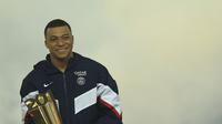 Bintang PSG, Kylian Mbappe bersama trofinya sebagai pencetak gol terbanyak sepanjang sejarah klubnya, Minggu (5/3/2023) dini hari WIB. (AP Photo/Aurelien Morissard)