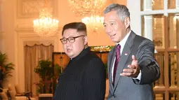 Perdana Menteri Singapura, Lee Hsien Loong menyambut kedatangan pemimpin Korea Utara Kim, Jong-un di Istana Kepresidenan Singapura, Minggu (10/6). Kim Jong Un dan Donald Trump akan bertemu pada 12 Juni. (AFP Photo/Roslan Rahman)