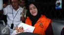 Suzanna memperlihatkan senyumnya saat berada di mobil tahanan usai menjalani pemeriksaan di Gedung KPK, Jakarta, Senin (6/7/2015). Ia dan suaminya resmi ditahan karena diduga menyuap mantan Ketua MK, Akil Mochtar. (Liputan6.com/Helmi Afandi)