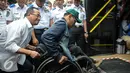 Menhub Budi Karya membantu penyandang disabilitas di Stasiun Gambir, Jakarta, Minggu (16/10). Budi meninjau fasilitas Integrasi Moda Transportasi yang ramah disabilitas (Liputan6.com/Faizal Fanani)