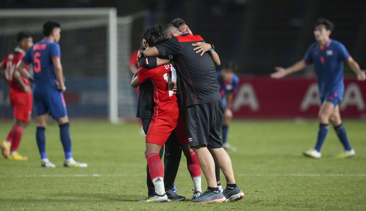 Pemain, pelatih, dan ofisial Timnas Indonesia U-22 merayakan kemenangan pada laga final sepak bola SEA Games 2023 melawan Thailand di Olympic Stadium, Phnom Penh, Kamboja, Selasa (16/05/2023). Skuad Garuda Nusantara menang dengan skor 5-2. (AP Photo/Tatan Syuflana)