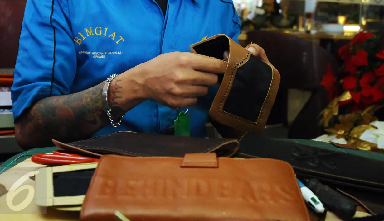 Salah satu warga binaan menyelesaikan pembuatan dompet pada Napi Craft 2015 di Kuningan,Jakarta, Senin (21/12/2015). Napi Craft 2015 memamerkan beragam hasil kreativitas warga binaan dari 12 Divisi Pemasyarakatan. (Liputan6.com/Helmi Fithriansyah)