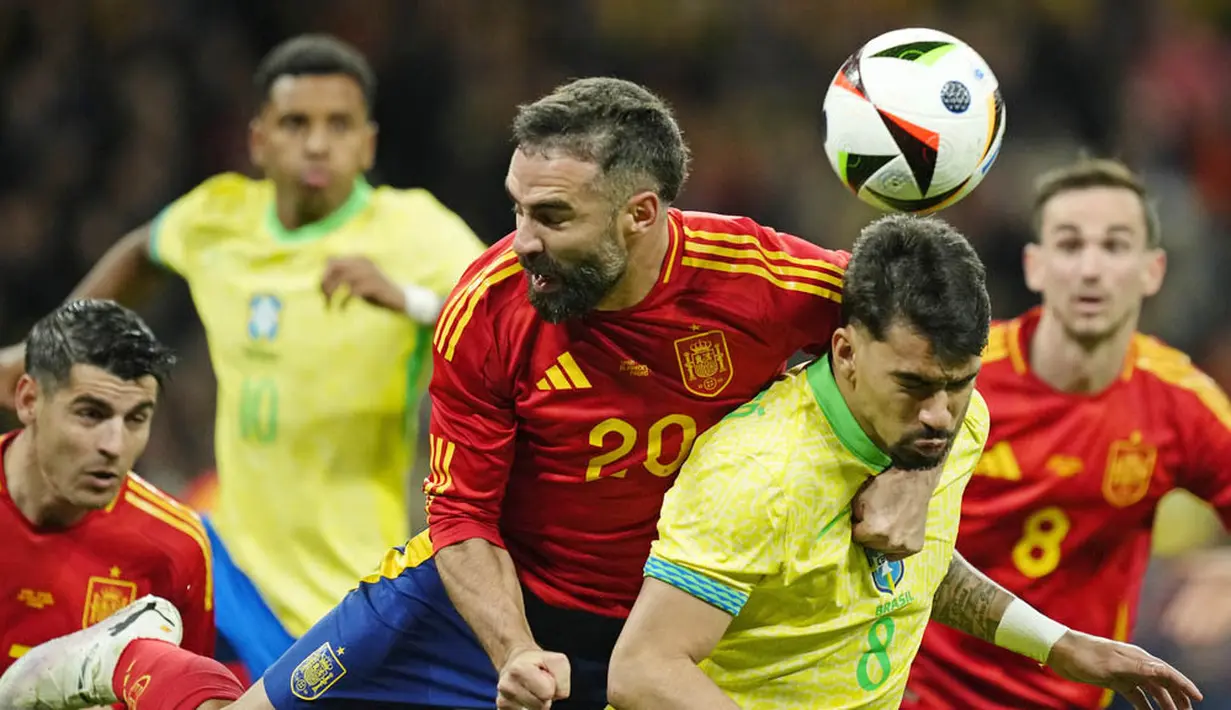Pemain asal Spanyol, Dani Carvajal, melakukan duel udara dengan pemain asal Brasil, Lucas Paqueta, dalam laga persahabatan di Stadion Santiago Bernabeu, Rabu (27/3/2024).  (Foto AP/Jose Breton)