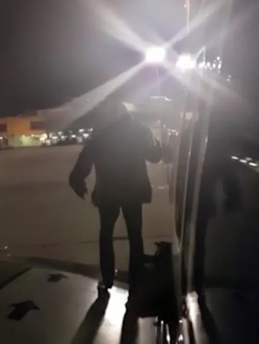 Seorang penumpang maskapai Ryanair keluar lewat pintu darurat di sayap pesawat di Bandara Malaga, Spanyol, Rabu (3/1). Pria itu dan penumpang lain mesti menunggu lama kabin untuk turun dari pesawat yang telah mendarat. (Fernando del Valle via AP)