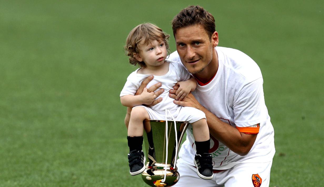 Kapten AS Roma, Francesco Totti, bersama sang putra, Cristian, merayakan gelar juara Piala Italia di Stadion Olimpico, Roma, Minggu (27/5/2007). (EPA/Ettore Ferrari)