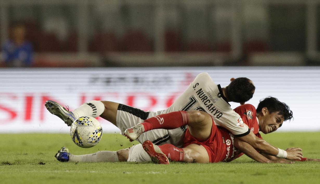 Gelandang Persija Jakarta, Fitra Ridwan, berebut bola dengan pemain Madura United pada laga Shopee Liga 1 di SUGBK, Jakarta, Jumat (13/12). Persija menang 4-0 atas Madura. (Bola.com/Yoppy Renato)