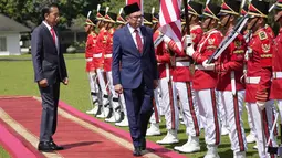 Presiden Joko Widodo atau Jokowi (kiri) bersama Perdana Menteri Malaysia Anwar Ibrahim (kedua kiri) memeriksa pasukan di Istana Kepresidenan Bogor, Jawa Barat, Senin (9/1/2023). Ini merupakan kunjungan pertama Anwar Ibrahim sejak dilantik menjadi PM Malaysia pada November 2022. (AP Photo/Achmad Ibrahim)