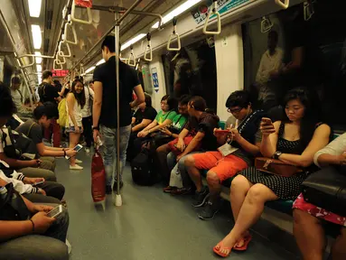 Sejumlah pengguna moda transportasi di Singapura terlihat berada di dalam kereta MRT, Minggu (31/5/2015). MRT menjadi sistem angkutan cepat yang membentuk tulang punggung dari sistem kereta api di Singapura. (Liputan6.com/Helmi Fithriansyah)