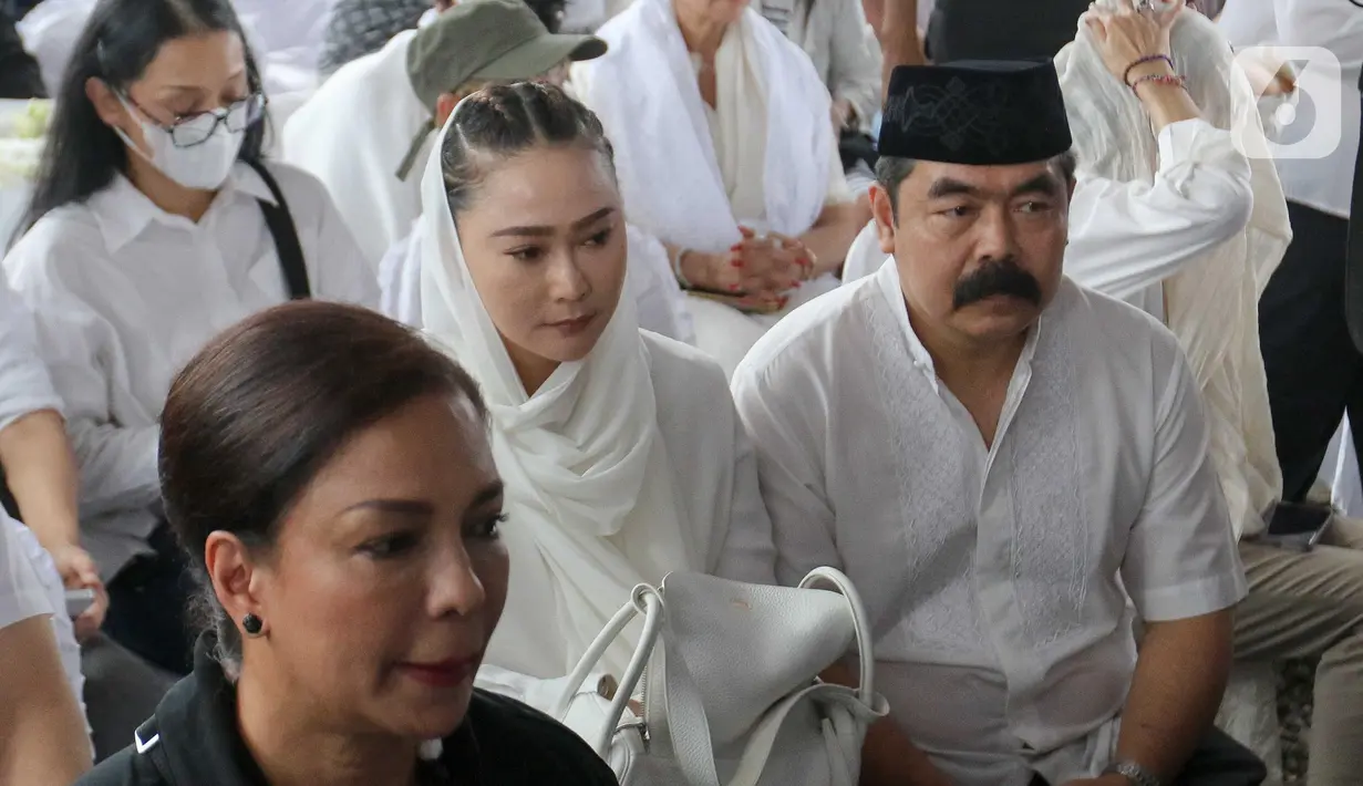 Pedangdut, Inul Daratista (tengah) bersama suaminya, Adam Suseno saat menyaksikan prosesi pemakaman penyanyi dan artis legendaris Titiek Puspa di Tempat Pemakaman Umum (TPU) Tanah Kusir, Jakarta Selatan, Jumat, 11 April 2025. (Liputan6.com/Herman Zakharia)
