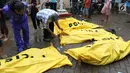 Warga melihat jenazah korban gelombang Tsunami Anyer di Puskesmas Carita, Banten, Minggu (23/12). Tim SAR masih melakukan pencarian jenazah yang sebagian besar berasal dari Pantai Carita. (Liputan6.com/Angga Yuniar)