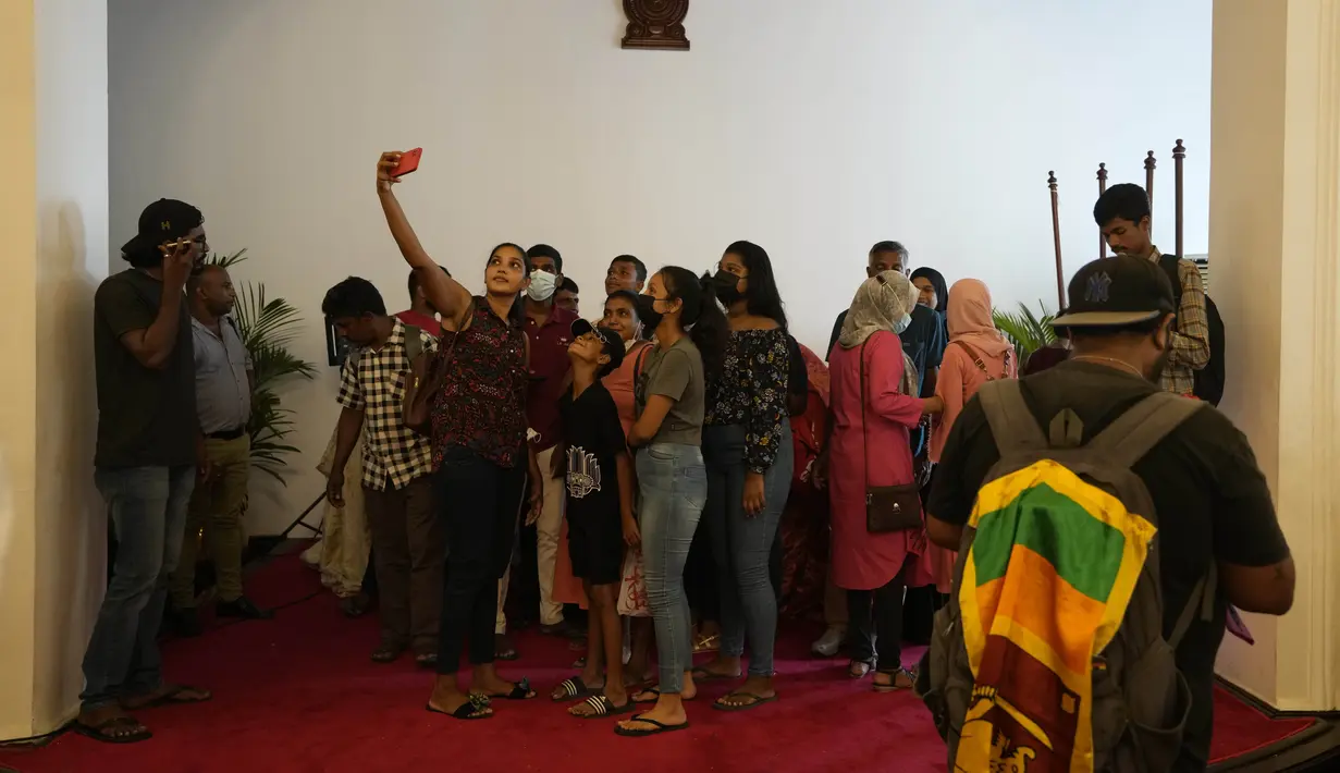 Seorang wanita berswafoto saat orang-orang memadati kediaman resmi Presiden Gotabaya Rajapaksa untuk hari kedua setelah diserbu di Kolombo, Sri Lanka, Senin (11/7/2022). (AP Photo/Eranga Jayawardena)