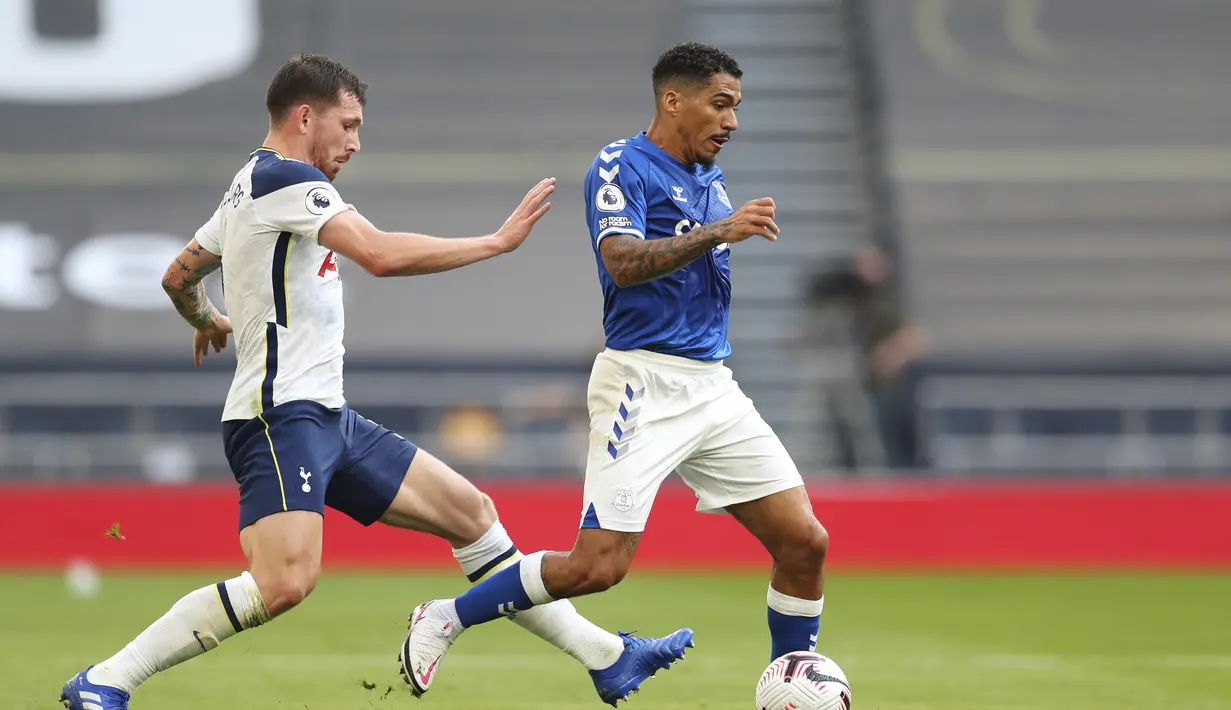 Gelandang Everton,  Allan berusaha membawa bola dari kawalan pemain Tottenham Hotspur, Pierre-Emile Hojbjerg pada pertandinga Liga Inggris di i Stadion Tottenham Hotspur di London, Minggu, (13/9/2020). Everton menang 1-0 atas Totttenham. (Cath Ivill/Pool via AP)