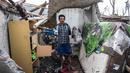 Seorang warga menyelamatkan barang-barang miliknya dari rumahnya yang rusak di desa Curah Kobokan di Lumajang, Jawa Timur, Rabu (8/12/2021). Akibat erupsi Gunung Semeru, sebagian besar rumah di desa tersebut runtuh. (Juni Kriswanto / AFP)