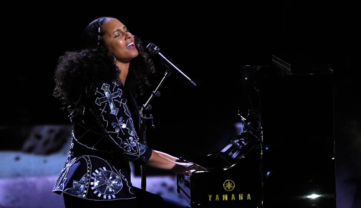 Aksi Alicia Keys memainkan piano saat membawakan lagu dalam acara WE Day California di Inglewood, California, AS (27/4). Penyanyi 36 tahun ini memutuskan tidak mengenakan make up sejak penampilannya di MTV VMA 2016. (AP Photo/Chris Pizzello)