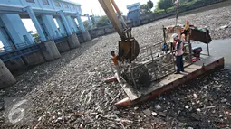 Petugas membersihkan sampah di Pintu Air Marunda Hilir, Jakarta, Selasa (17/5). Perilaku buruk warga buang sampah sembarangan menyebabkan sampah selalu menumpuk di pintu air tersebut, meskipun setiap hari dibersihkan. (Liputan6.com/Immaniel Antonius)