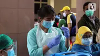 Vaksinator menyiapkan vaksin COVID-19 saat vaksinasi massal di Gedung Pemerintah Kota Tangerang, Banten, Kamis (25/2/2021). Vaksinasi ini dilaksanakan hingga satu minggu ke depan. (Liputan6.com/Angga Yuniar)