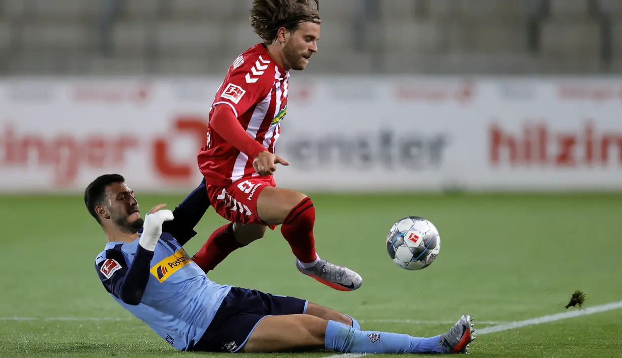 Bek Borussia Monchengladbach, Ramy Bensebaini, berebut bola striker SC Freiburg, Lucas Hoeler, pada laga lanjutan Bundesliga di Freiburg, Jumat (5/6/2020) waktu setempat. Monchengladbach kalah 0-1 atas Freiburg. (AFP/Ronald Wittek/Pool)