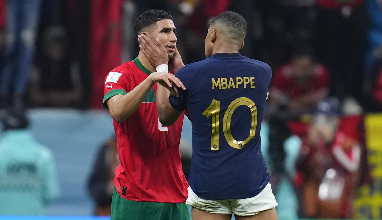 <p>Pemain Prancis, Kylian Mbappe (kanan) menghibur pemain Maroko, Achraf Hakimi setelah laga semifinal Piala Dunia 2022 yang berlangsung di Al Bayt Stadium, Qatar, Rabu (14/12/2022) waktu setempat. (AP Photo/Manu Fernandez)</p>