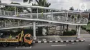 Petugas Sudin Bina Marga Jakarta Timur memperbaiki jembatan penyeberangan orang (JPO) di Jalan Otto Iskandardinata (Otista), Jatinegara, Rabu (9/2/2022). Perbaikan JPO itu tindak lanjut pasca insiden tertimpa pohon tumbang pada November tahun lalu akibat cuaca ekstrem. (merdeka.com/Iqbal S Nugroho)