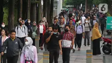 Sejumlah pekerja mengenakan masker melintas saat jam pulang kerja di kawasan Sudirman, Jakarta, Rabu (16/8/2023). (Liputan6.com/Angga Yuniar)