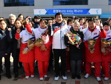 Tim hoki es Korea Utara berfoto bersama tim Korea Selatan di pusat pelatihan nasional Jincheon, Korsel (25/1). Tim hoki es dari Korut ini akan mengkuti olimpede musim dingin bersama tim Korea Selatan sebagai tim gabungan. (AFP Photo/Pool/ Kyung-Seok)