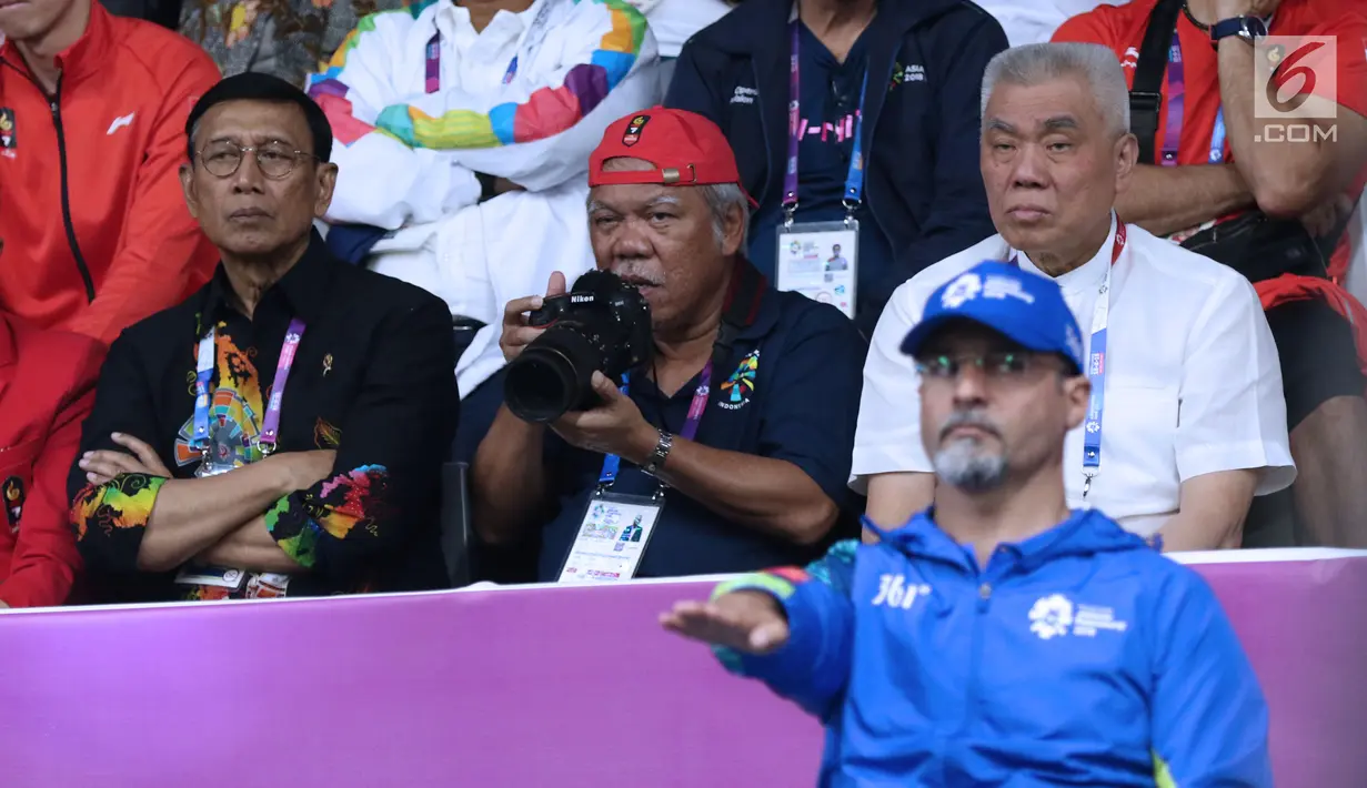 Menteri PUPR, Basuki Hadimuljono bersiap mengabadikan momen saat laga semifinal bulu tangkis beregu putra Asian Games 2018, Indonesia melawan Jepang di Jakarta, Selasa (21/8). Indonesia unggul dan lolos ke final. (Liputan6.com/Helmi Fithriansyah)