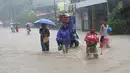 Sejumlah warga menyeberangi jalan yang terendam banjir usai badai tropis Linfa melanda wilayah San Fernando, La Union, Filipina, Senin (6/7/2015). Badai tropis Linfa yang memiliki kecepatan 100 km per jam itu sedang bergerak ke utara. (REUTERS/TJ Corpuz)