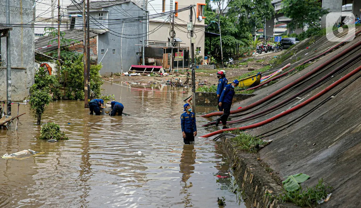 Petugas pemadan kebakaran menyedot air banjir di kawasan Cipinang Melayu, Jakarta, Minggu (21/2/2021). Suku Dinas Pemadam Kebakaran Jakarta Timur mengerahkan 20 mobil pompa untuk menyedot air yang membanjiri RW 04 Kelurahan Cipinang Melayu untuk mengurangi debit air. (Liputan6.com/Faizal Fanani)