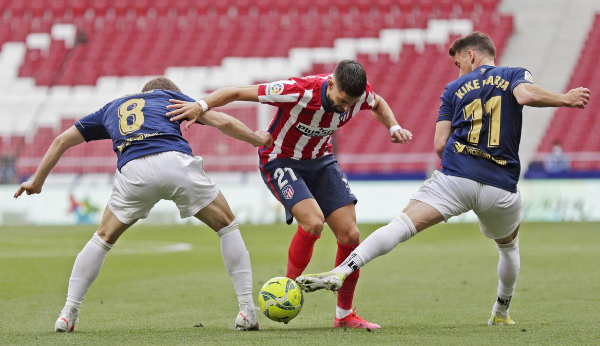 Pemain Atletico Madrid, Yannick Carrasco, berusaha melewati pemain Osasuna pada laga Liga Spanyol di Stadion Wanda Metropolitano, Minggu (16/5/2021). Atletico Madrid menang dengan skor 2-1. (AP/Manu Fernandez)
