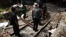 Sejumlah pekerja PT KAI melakukan perbaikan pembatas antara rel dan ruang tunggu penumpang di Stasiun Kota, Jakarta, Jumat (26/12/2014). (Liputan6.com/Faizal Fanani)