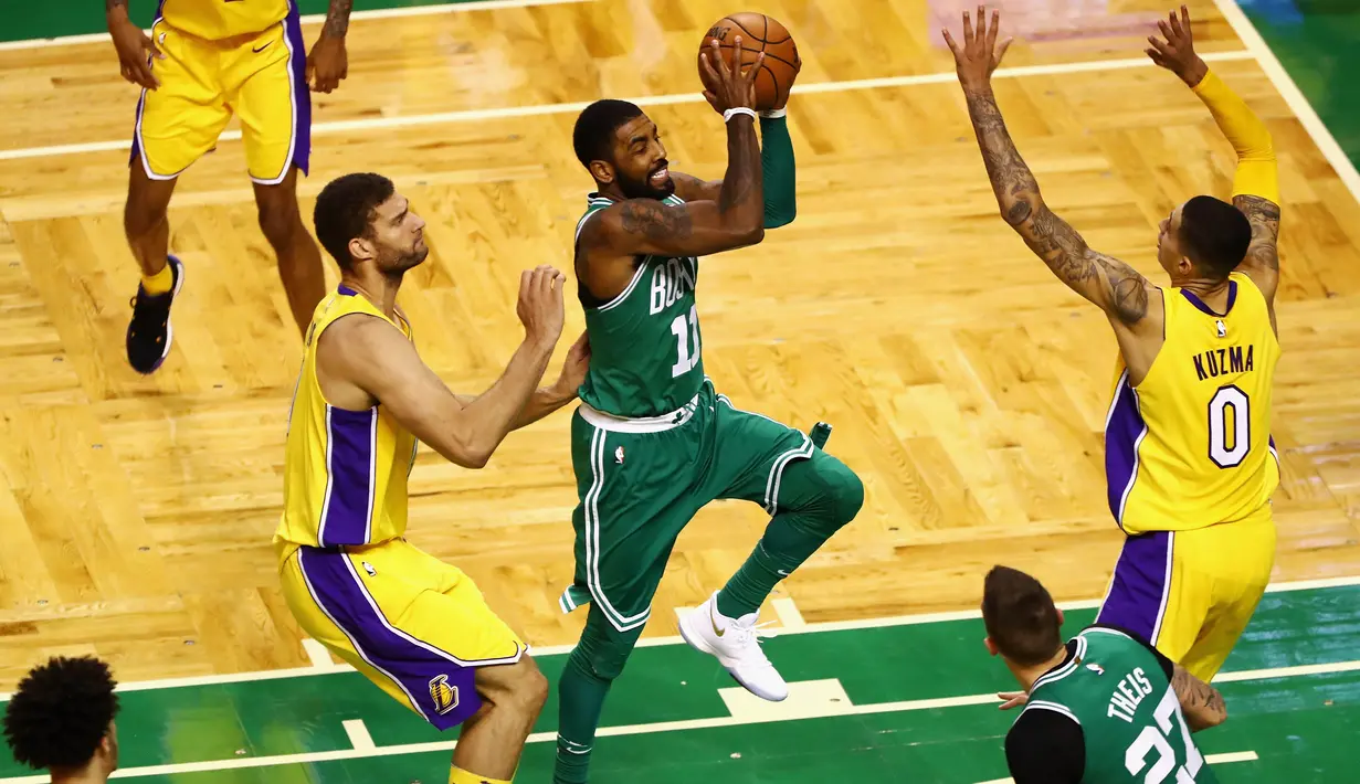 Aksi pemain Boston Celtics, Kyrie Irving #11 melewati adangan para pemain Los Angeles Lakers pada laga NBA basketball game di TD Garden, Boston, (8/11/2017). Celtics menang 107-96.   (Tim Bradbury/Getty Images/AFP)