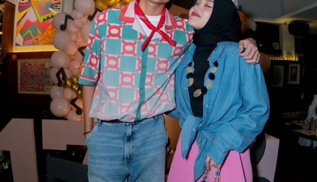 Putri Delina nggak kalah seru. Ia tampil dengan padu padan denim shirt tanpa dikancing, hanya diikat menjadi model crop. Ia memadukannya dengan loose pants dan topi pink. Dipermanis dengan kalung berukuran besar.  [@rizwanfadilah.a.s]