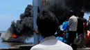 Sejumlah warga menyaksikan petugas BNN membakar kapal 6633 pengangkut 862 kg sabu di Dadap, Tangerang, Banten, Selasa (10/3). Kapal milik jaringan narkotika internasional pimpinan WCP itu dimusnahkan dengan cara dibakar. (Liputan6.com/Faisal R Syam)