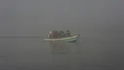 Orang-orang naik perahu di Sungai Ravi saat kabut tebal menyelimuti Lahore, Pakistan, Selasa (30/11/2021). Lahore secara konsisten menempati peringkat sebagai salah satu kota terburuk di dunia untuk polusi udara. (AP Photo/K.M. Chaudary)