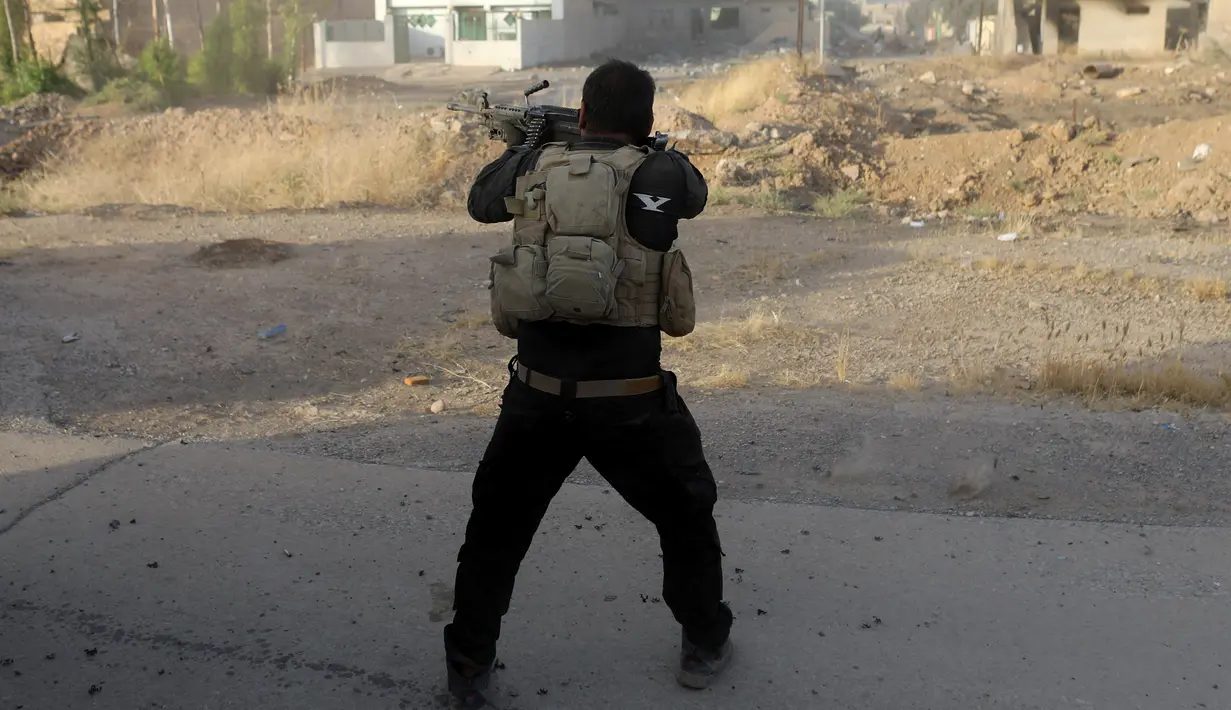 Seorang tentara pasukan khusus Irak menembakan senjata dalam bentrokan dengan ISIS di Bartella, timur Mosul, Irak, (20/10). (REUTERS/Goran Tomasevic)