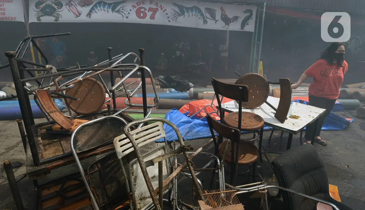 Warga melihat pendinginan rumah dan kios yang terbakar di Jalan Minangkabau, Jakarta, Selasa (7/7/2020). Delapan unit mobil pemadam kebakaran dikerahkan untuk memadamkan api yang hingga saat ini belum diketahui penyebab kebakaran. (merdeka.com/Imam Buhori)