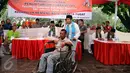 Petugas KPPS mengantar penyandang disabilitas menuju bilik suara dalam simulasi pemungutan dan penghitungan suara Pilkada DKI Jakarta di Taman Menteng, Sabtu (28/1). Simulasi ini dilaksanakan oleh KPUD Jakarta Pusat. (Liputan6.com/Helmi Fithriansyah)