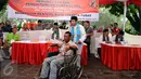 Petugas KPPS mengantar penyandang disabilitas menuju bilik suara dalam simulasi pemungutan dan penghitungan suara Pilkada DKI Jakarta di Taman Menteng, Sabtu (28/1). Simulasi ini dilaksanakan oleh KPUD Jakarta Pusat. (Liputan6.com/Helmi Fithriansyah)