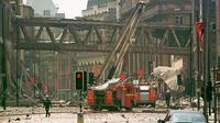 Petugas pemadam kebakaran berjalan di tengah puing-puing di lokasi ledakan bom di pusat Manchester, 180 mil utara London, 15 Juni 1996. (AP)