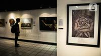 Pengunjung mengamati lukisan yang ditampilkan dalam pameran bertajuk "Hai, Kamu!" di Balai Budaya, Jakarta, Kamis (4/11/2021). Pameran untuk mengenang penyair WS Rendra (1935-2009) ini menampilkan 19 karya dari 15 pelukis yang terinspirasi dari karya puisi WS Rendra. (Liputan6.com/Faizal Fanani)