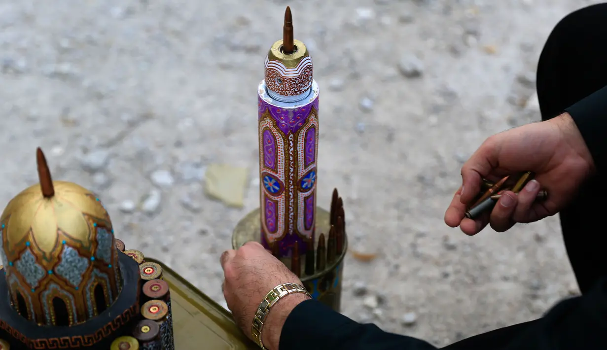 Seniman Suriah, Akram Abu Elfoz (37) memberikan sentuhan akhir pada replika Masjid Al-Rawdah yang dibuat dari selongsong peluru dan sisa amunisi perang, di sebelah timur Suriah, Ibu Kota Damaskus, 3 Juni 2016.  (AFP PHOTO/Sameer Al - Doumy) 