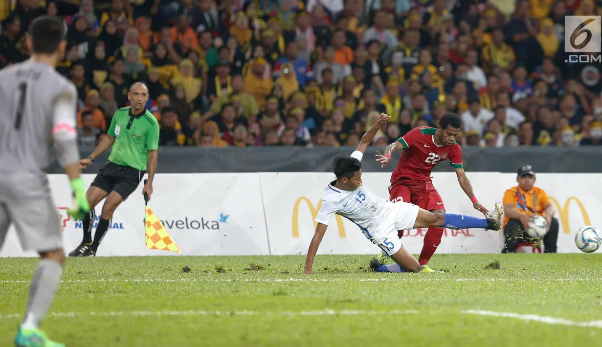 Pemain tuan rumah Malaysia berusaha merebut bola Pemain Timnas U-22 Yabes Roni pada pertandingan Sepak Bola Indonesia melawan Malaysia di Stadion Shah Alam, Selangor, Sabtu (26/08). (Liputan6.com/Faizal Fanani)