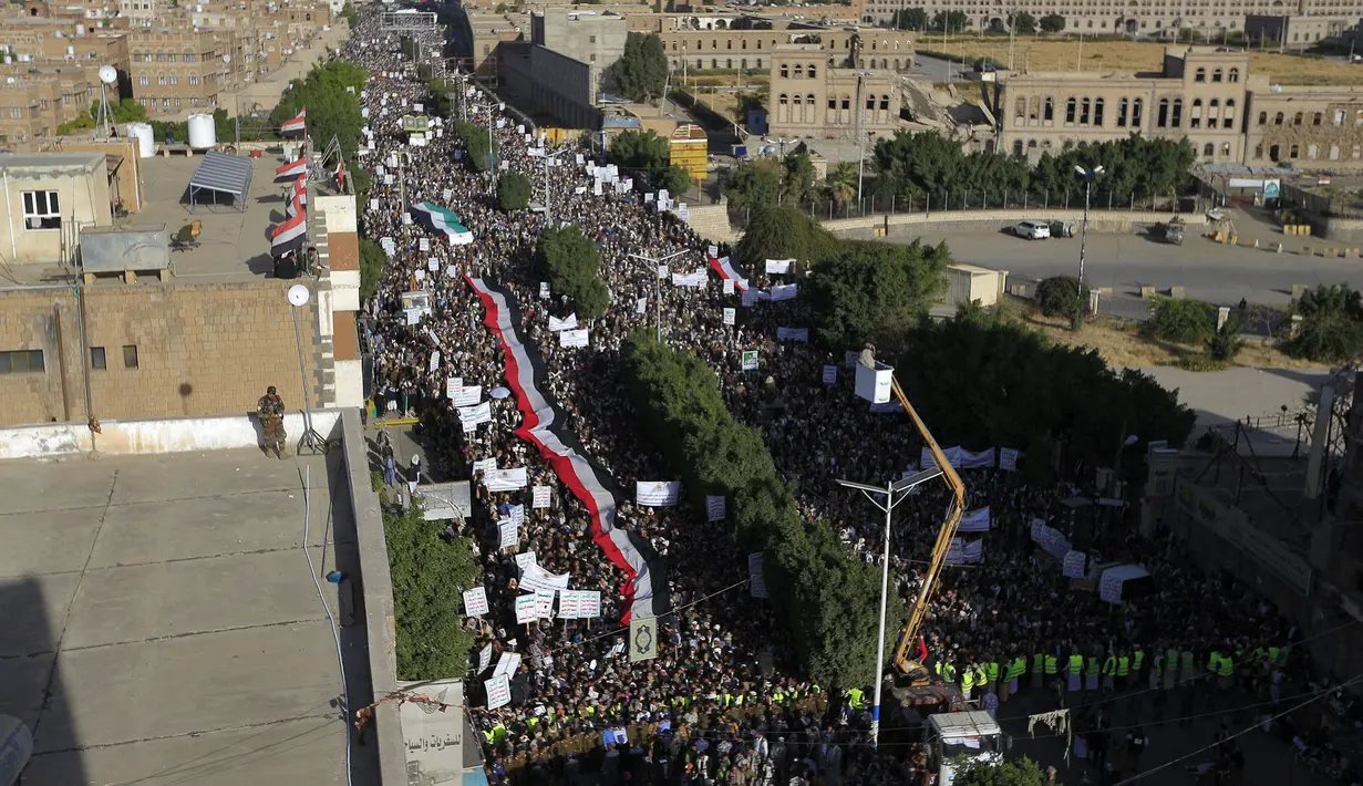 Bendera Yaman dibentangkan saat demonstrasi mengecam pembakaran Al-Quran oleh seorang politisi Swedia di ibu kota Sanaa pada 23 Januari 2023. Ribuan warga Yaman di ibu kota Sanaa turut berunjuk rasa. (AFP/Mohammed Huwais)